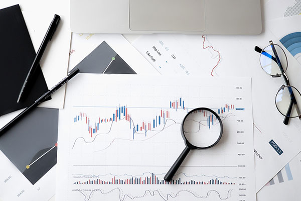 table with charts, a magnifying glass, and glasses